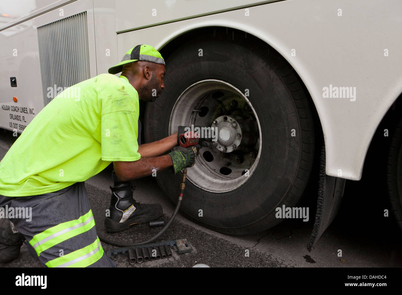 Mechaniker, eine Bus-Rad mit einem Schlagschrauber entfernen Stockfoto