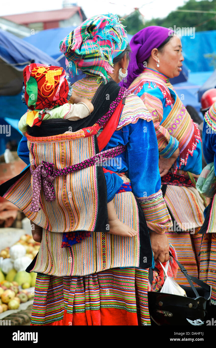 Flower Hmong Frau mit Kind auf dem Rücken am Markt von Bac Ha, Vietnambaby Stockfoto