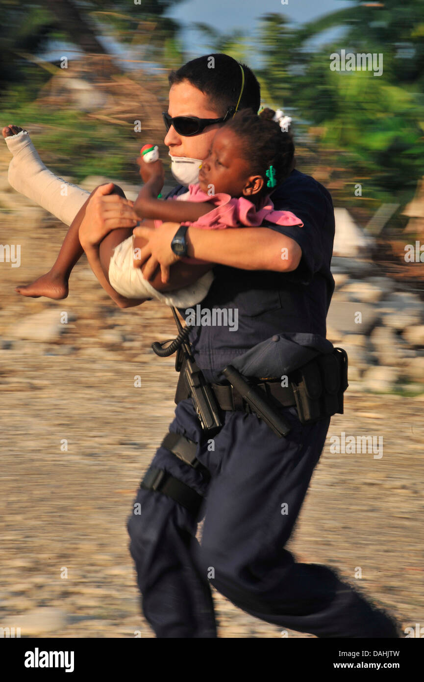 Ein US-Küste-Gardisten eilt eine verletzte haitianische Mädchen eine Evakuierung Hubschrauber im Anschluss an ein Erdbeben der Stärke 7,0, die 220.000 Menschen 19. Januar 2010 in Killick, Haiti getötet. Stockfoto