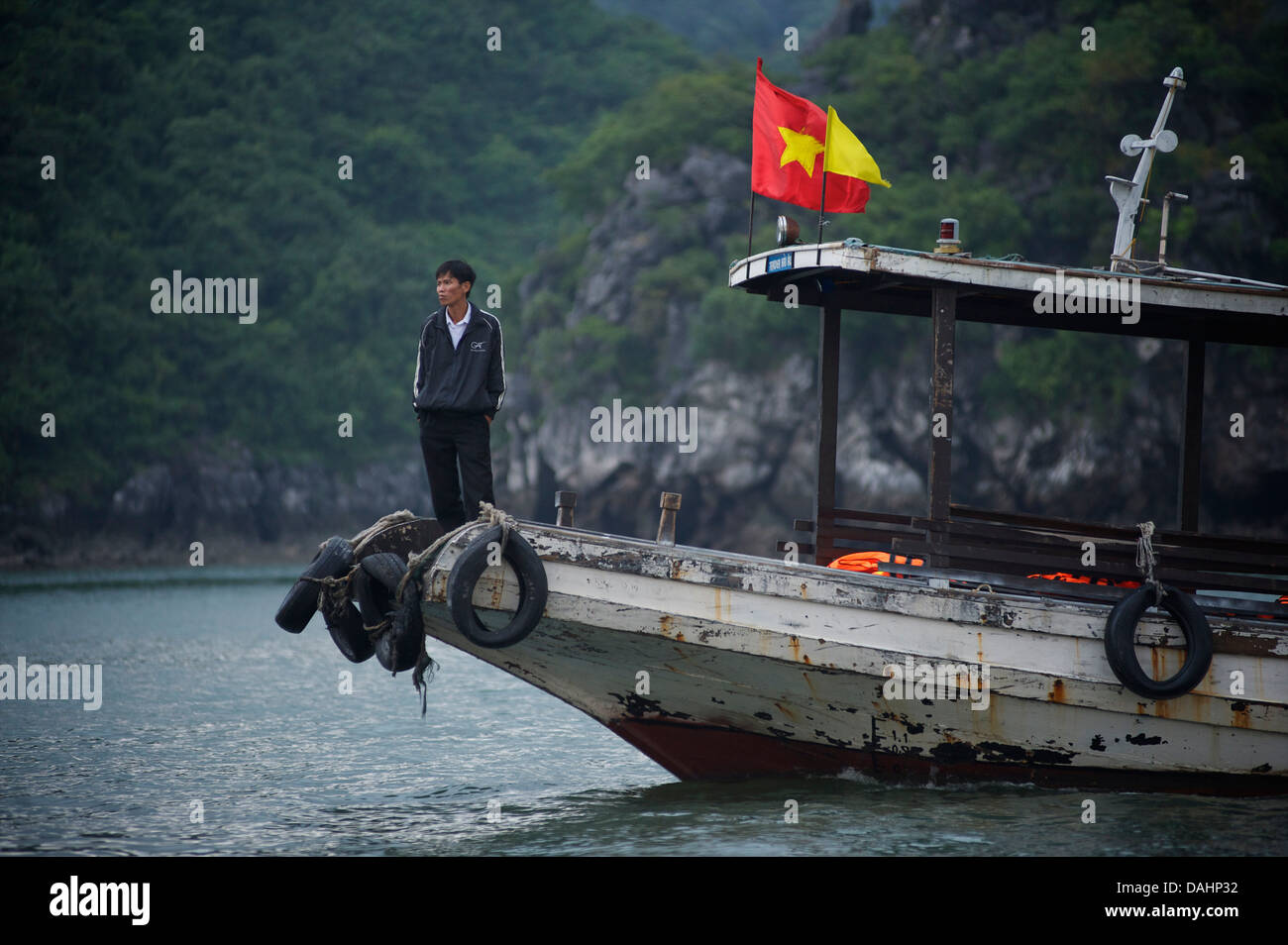 Vietnamesische Mann stand auf einem Boot, Halong Bucht, Vietnam Stockfoto