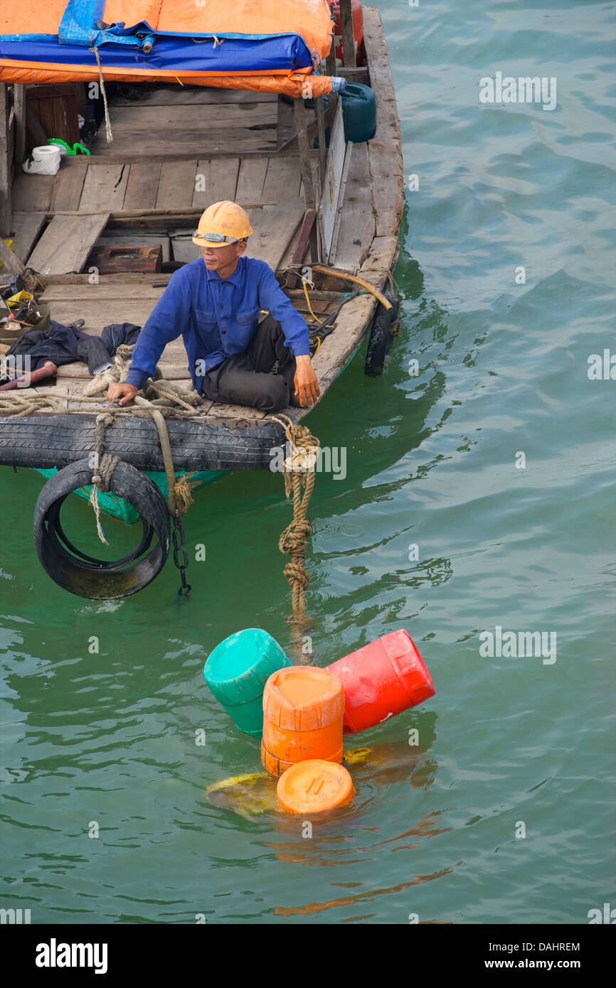 Fischer mit seinem Boot zwischen Halong-Bucht und 'Cat Ba' Island, Vietnam Stockfoto