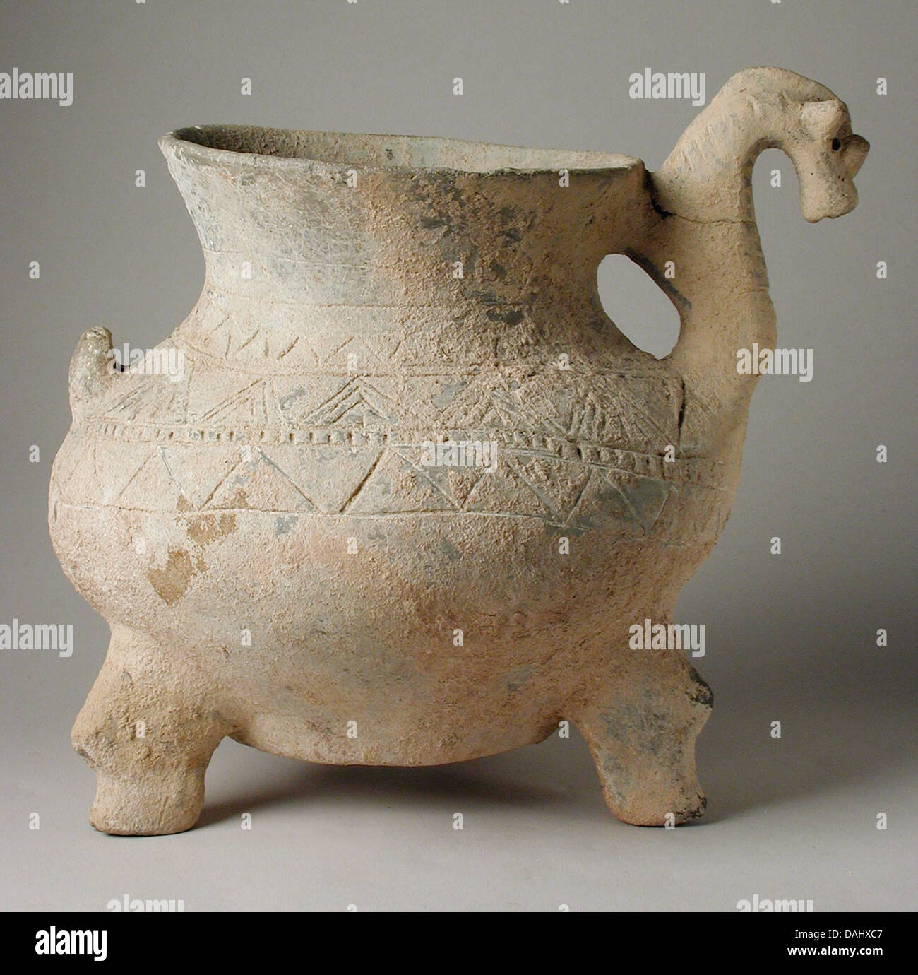 Dieser Keramikstativbecher verfügt über einen zoomorphen Griff, der die künstlerische Mischung von Form und Funktion in der antiken Keramik veranschaulicht. Sein Design spiegelt sowohl den praktischen Gebrauch als auch die symbolische Darstellung in alten Kulturen wider. Stockfoto
