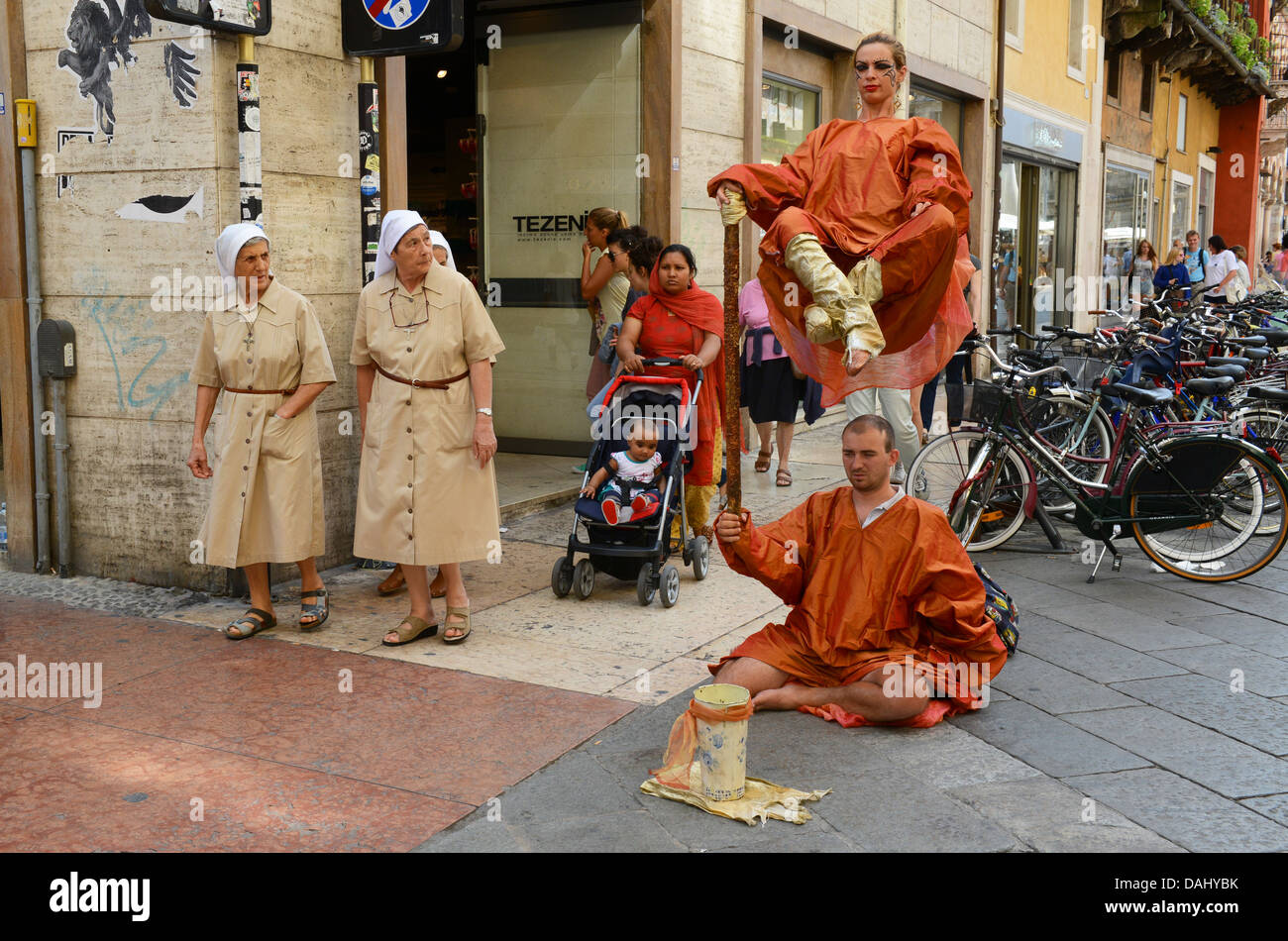 Straßenkünstler, beobachtet von Nonnen in Verona Italien. Bild von DAVID BAGNALL Stockfoto