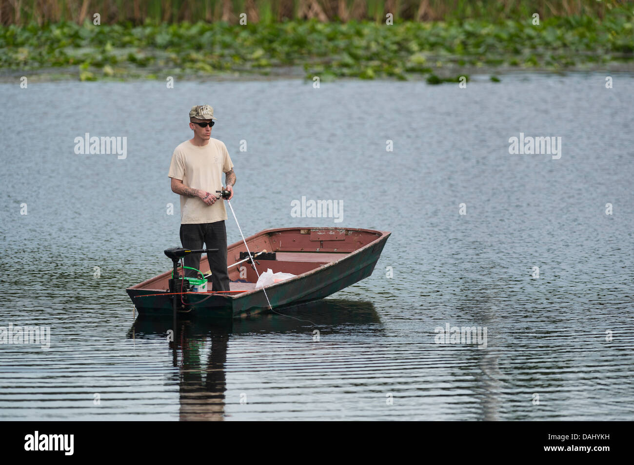 Ein dünner Mann stehen und Fischen von einem kleinen Ruderboot am Fluss Haines Creek Lake County Leesburg, Florida USA Stockfoto