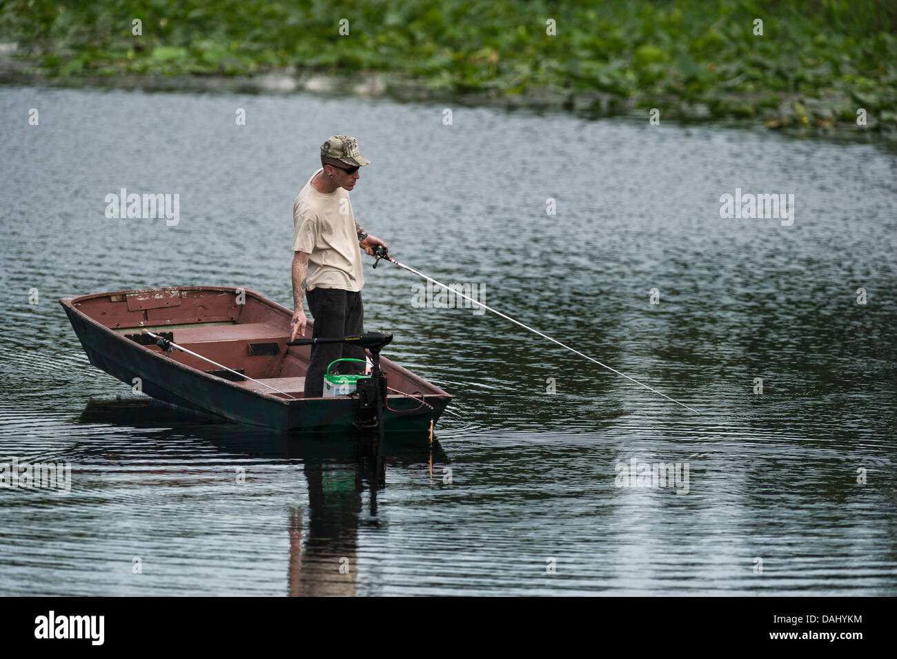 Ein dünner Mann stehen und Fischen von einem kleinen Ruderboot am Fluss Haines Creek Lake County Leesburg, Florida USA Stockfoto