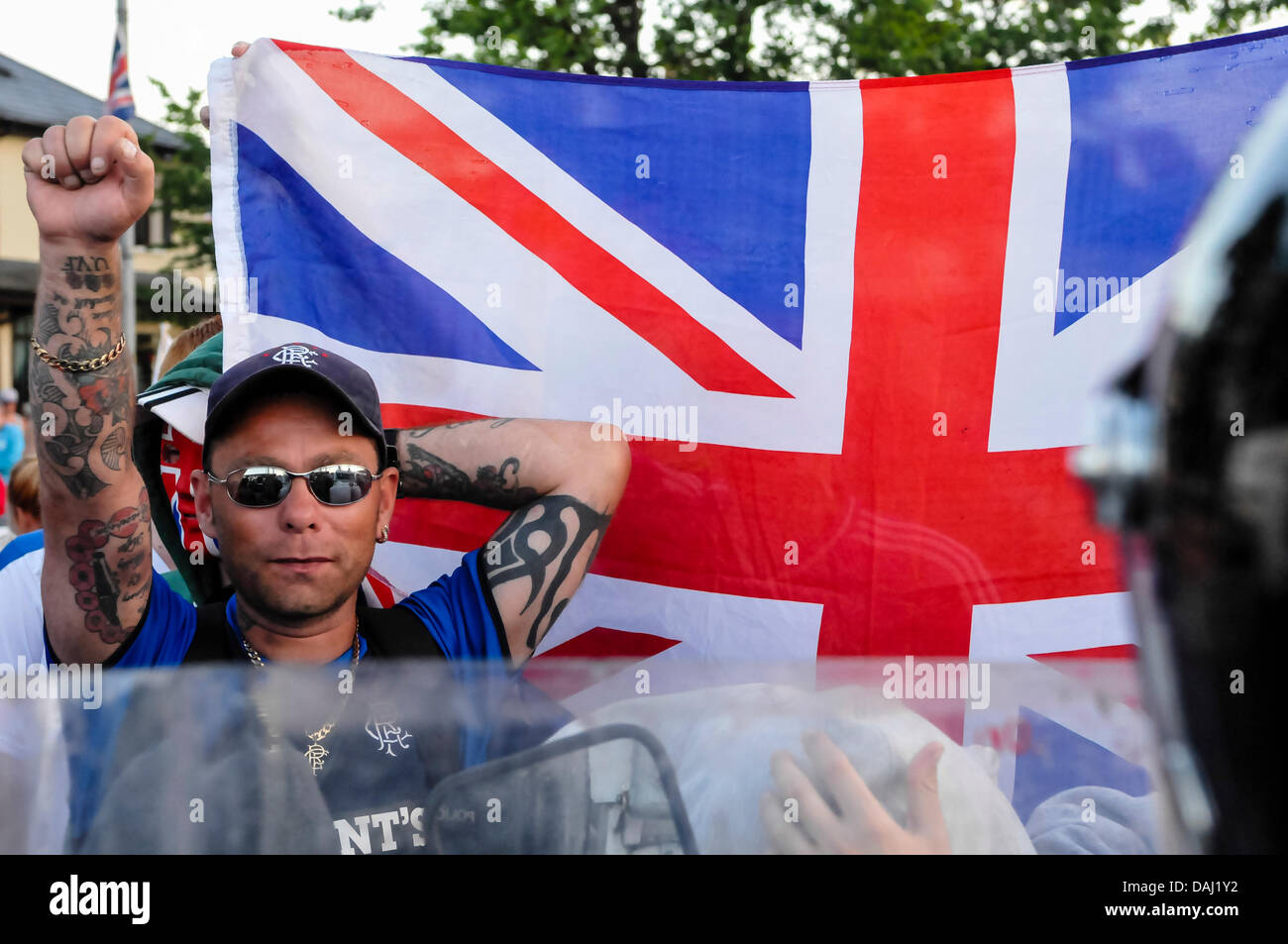 Belfast, Nordirland, 14. Juli 2013 - ein Demonstrant Loyalist gibt einen trotzigen Gruß neben einer Union Flag-Credit: Stephen Barnes/Alamy Live News Stockfoto