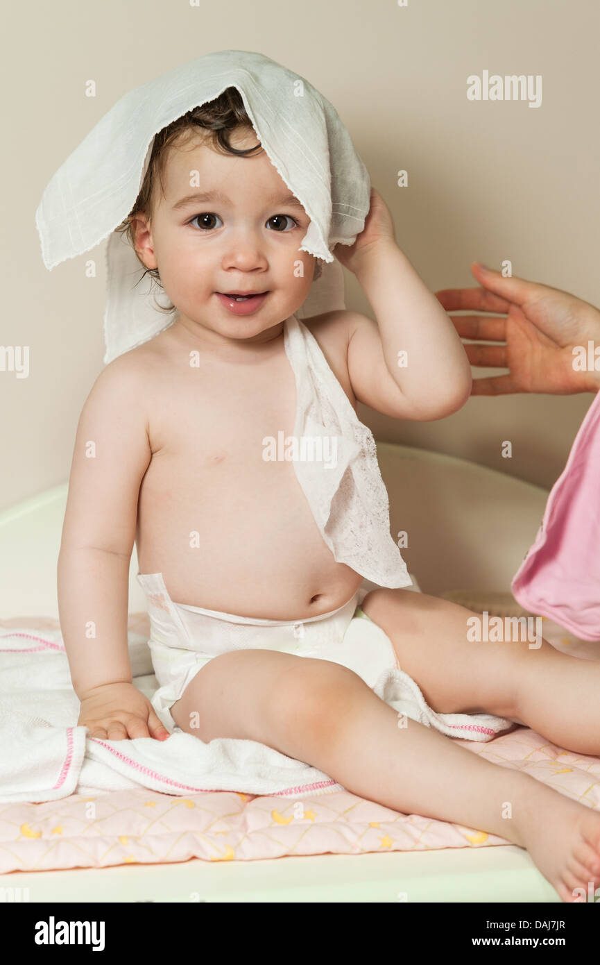 Niedliche Babymädchen, das ihr Haar sich mit Rasen nach Duschen getrocknet Stockfoto