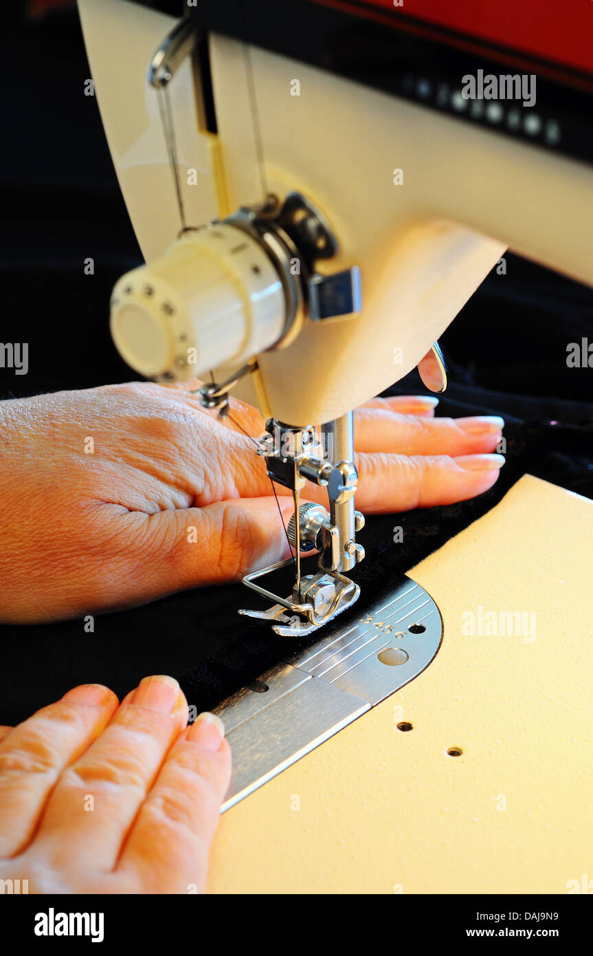 Frau mit einem inländischen elektrische Nähmaschine Black Velvet zu nähen. Stockfoto