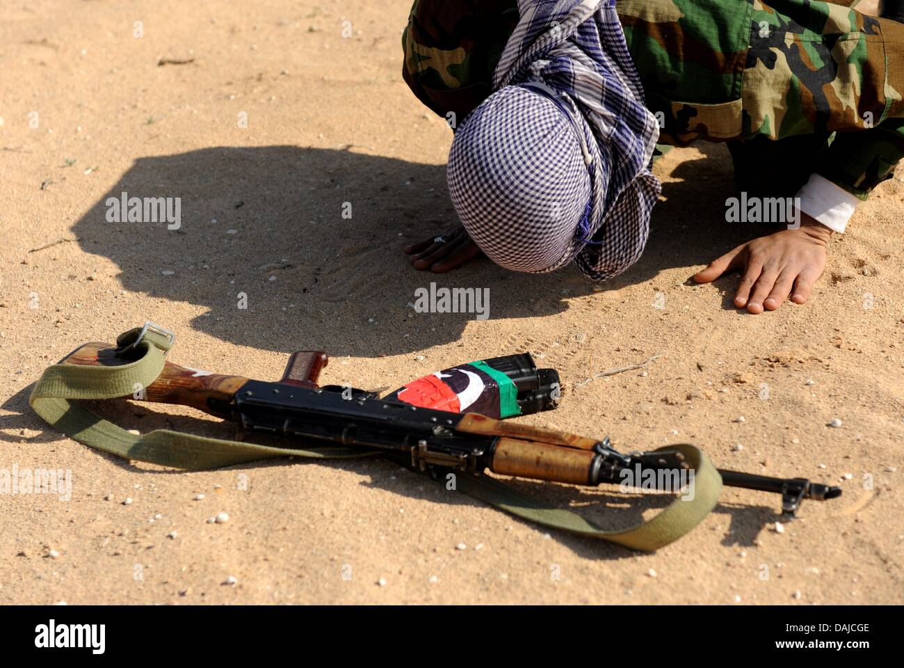 Eine libysche Rebellenkämpfer betet in der Nähe der Stadt von Al-Brega, Libyen, 4. April 2011. Al-Brega war der Ort der schweren Kämpfen in den letzten Wochen Besitzer sechsmal zwischen Regierung und Opposition Kräfte wechseln. Foto: MAURIZIO GAMBARINI Stockfoto