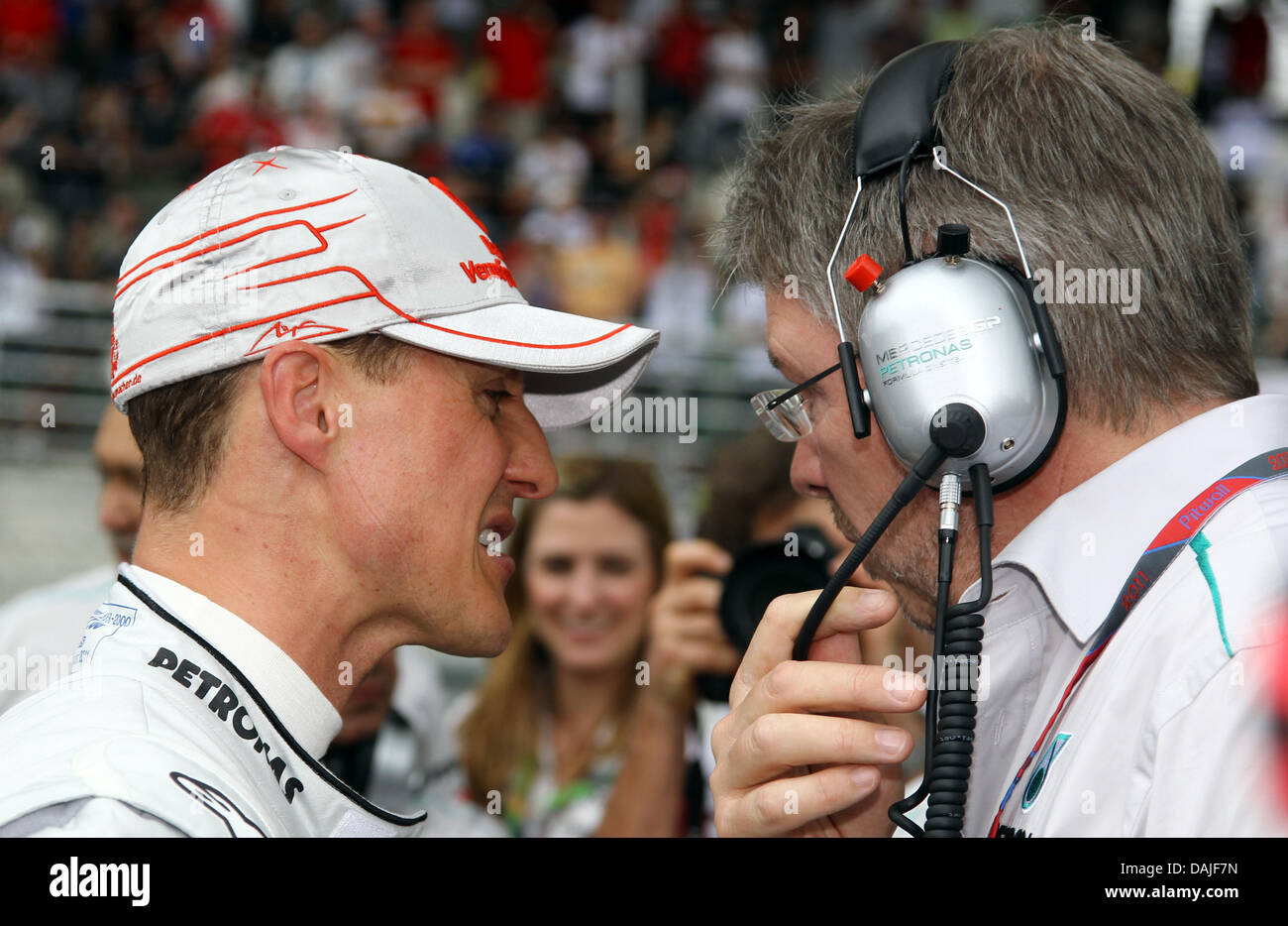 Deutsche Formel1 Rennfahrer Michael Schumacher (L) von Mercedes GP spricht mit Teamchef Ross Brawn vor dem Start des malaysischen Grand Prix der Formel 1 Grand Prix von Malaysia auf dem Sepang Circuit außerhalb Kuala Lumpur, Malaysia, 10. April 2011. Foto: JENS Büttner Stockfoto