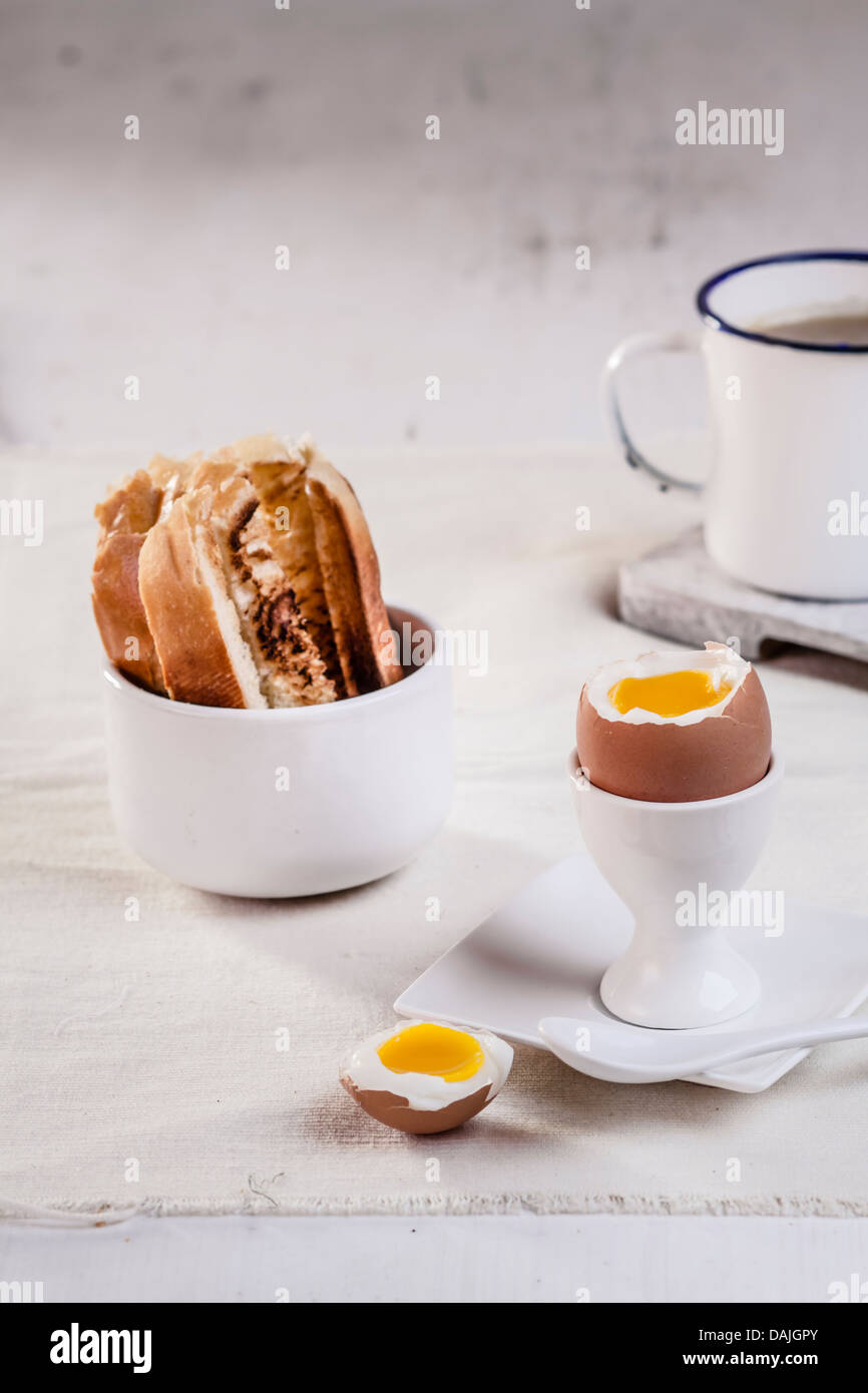 Ei im Eierbecher mit geröstetem Weißbrot und Kaffeetasse, Nahaufnahme Stockfoto