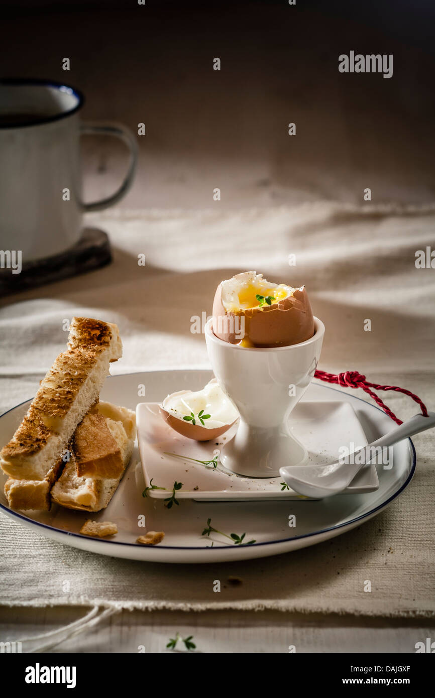 Ei mit getoastetem Weißbrot auf Platte und Kaffee-Becher, Nahaufnahme Stockfoto