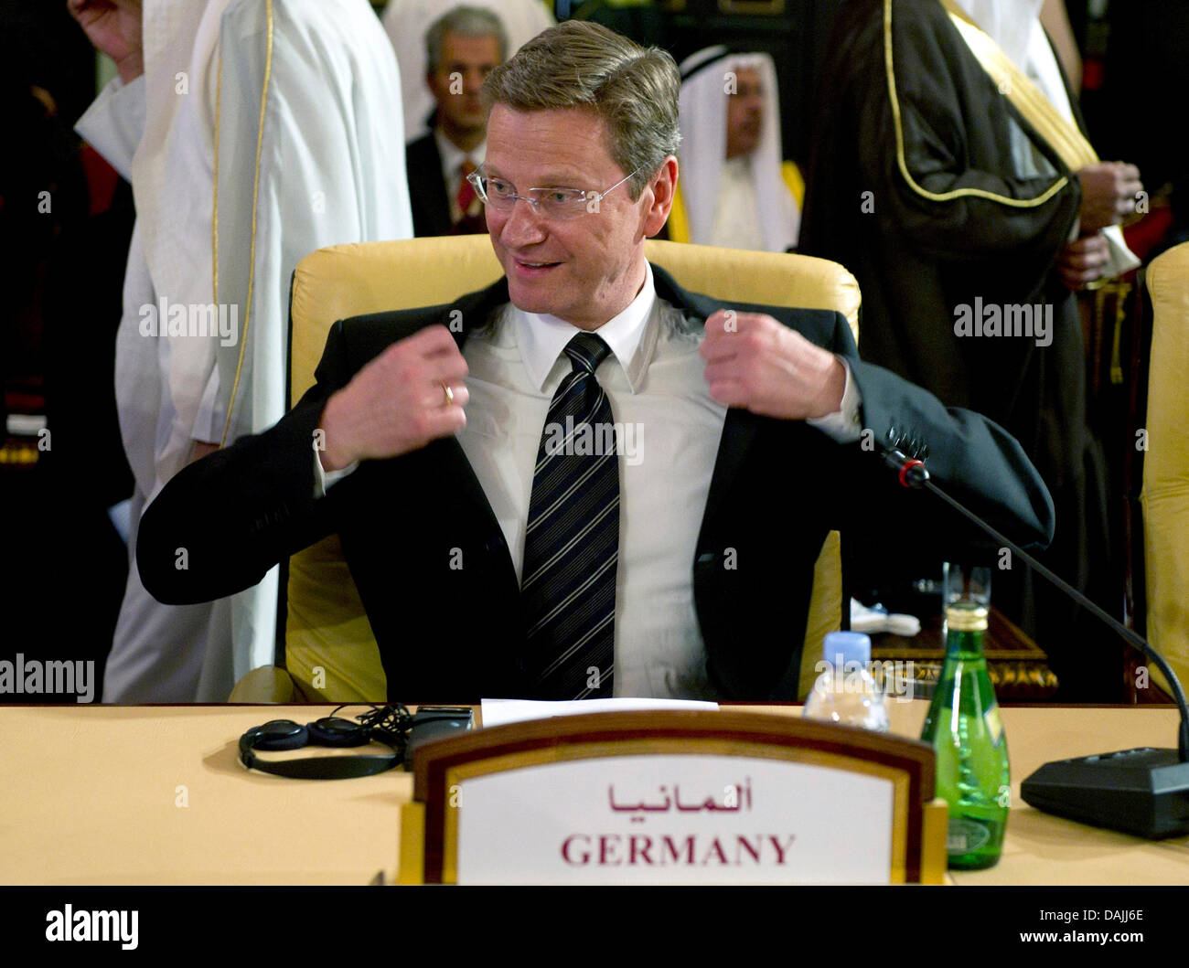 Der deutsche Außenminister Guido Westerwelle nimmt einen Sitz und lächelt während eines Treffens der Libyen-Kontaktgruppe in Doha, Katar, 13. April 2011. Die Politiker wollen politische Verfahren in Libyen weiter zu verhandeln. Foto: Peer Grimm Stockfoto