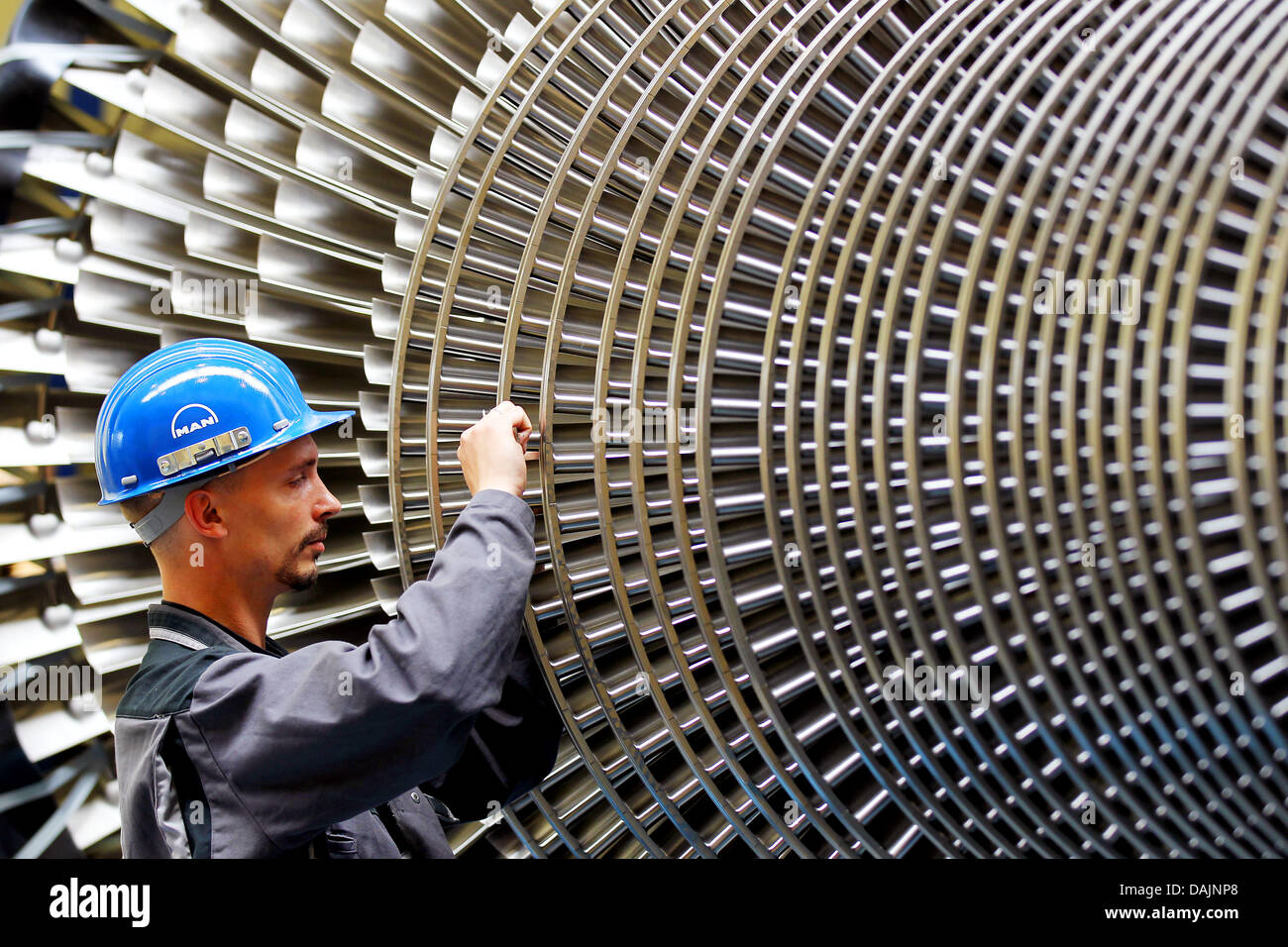 Ein Datei-Bild aufgenommen am 2. Juni 2010 zeigt eine Arbeitskraft mit einer Turbine bei MAN Turbo in Oberhausen, Deutschland. Wirtschaftsforschungsinstitute haben des erwartete Wirtschaftswachstums um 2,8 Prozent für Deutschland erhoben. Foto: Oliver Berg Stockfoto