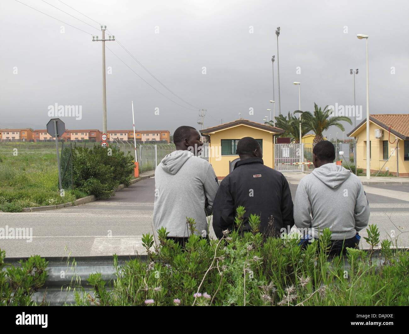 Männer aus der Elfenbeinküste töten Zeit vor dem Flüchtlingslager in der Nähe von Mineo, Italien, 30. April 2011. Im isolierten Lager sind 1600 Menschen aus mehr als 30 Ländern untergebracht, einschließlich von Côte d ' Ivoire oder Eritrea, viele Menschen, die in Libyen arbeitete, bevor der Krieg ausbrach. Sie warten auf den Beginn einer geordneten Asylverfahren, aber nach einigen Aussage, wissen sie nicht, die DAT-Dateien Stockfoto