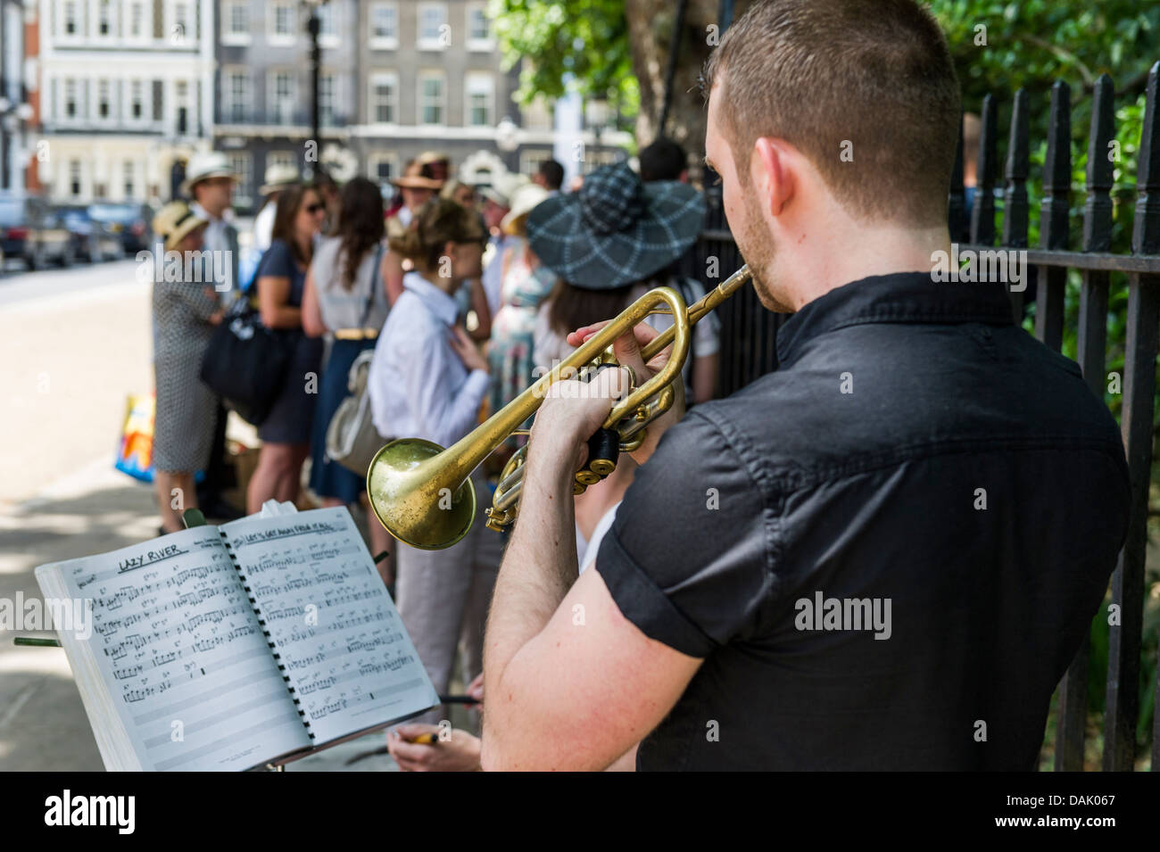 Ein Trompeter, der unterhaltsam der Menschen, wie sie die Warteschlange um Bedford Square Gardens für den Start der Chaps-Olympiade teilzunehmen. Stockfoto