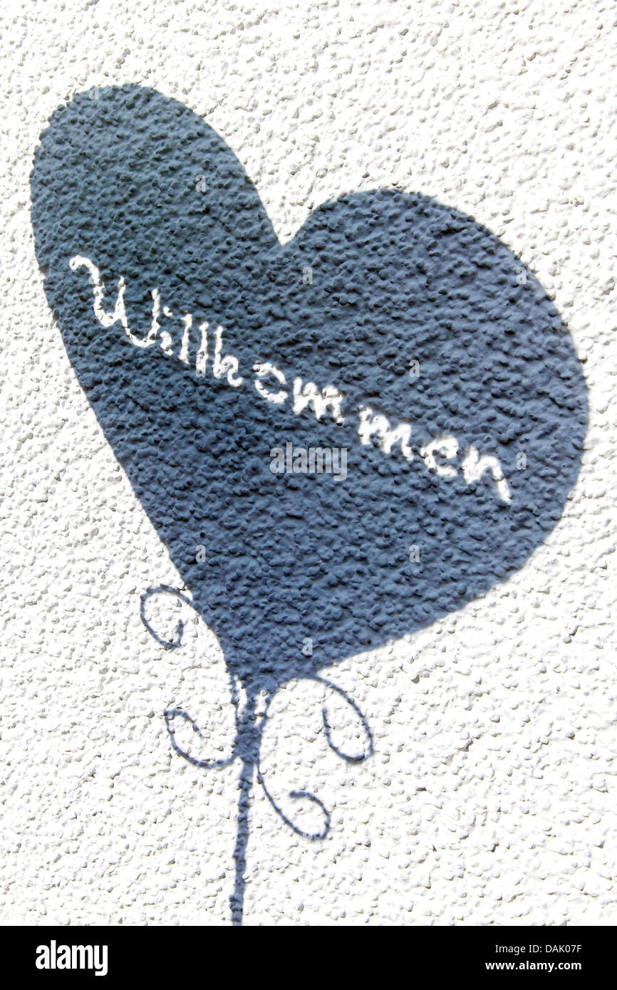 Herz mit dem Wort "Willkommen", Deutsch für "Willkommen", an der Wand Stockfoto