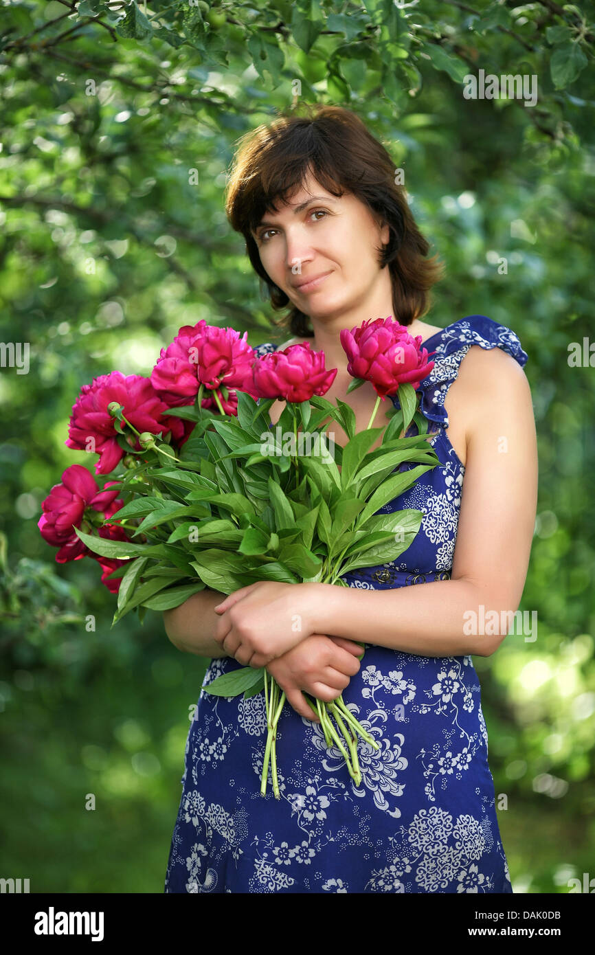 Die durchschnittliche Frau mit Blumen in einem Garten Stockfoto