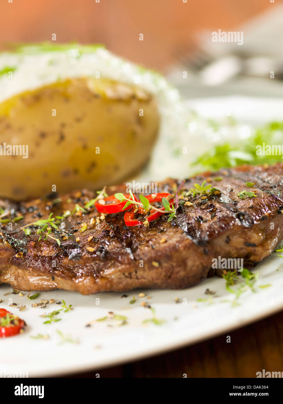 Rumpsteak mit Ofenkartoffel auf quadratischen Platte, Nahaufnahme Stockfoto