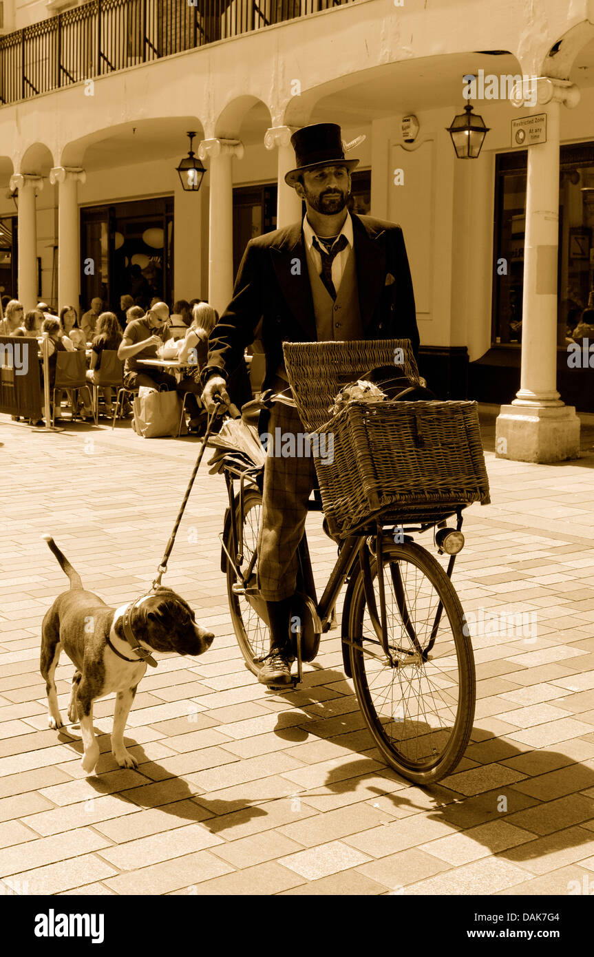 Englischer Gentleman mit smart alte Mode-Erscheinung mit seinem Fahrrad während der Einnahme von seinem Hund für einen Spaziergang an der New Road, Brighton Stockfoto