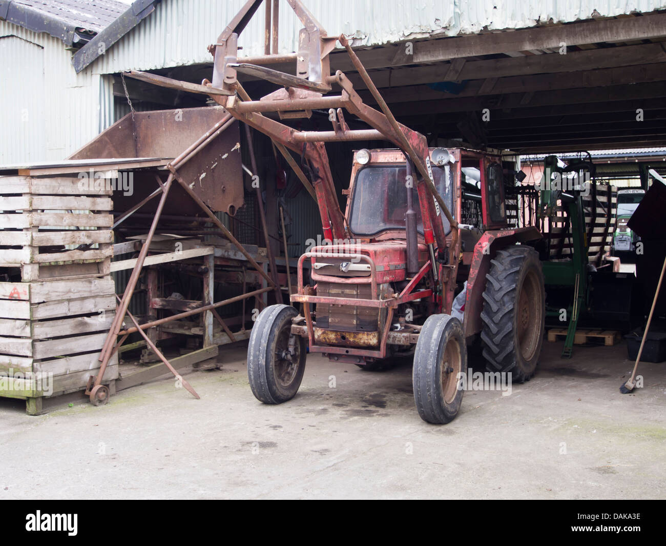 Alte rostige und roten Traktor in einem Bauernhof Schuppen Stockfoto
