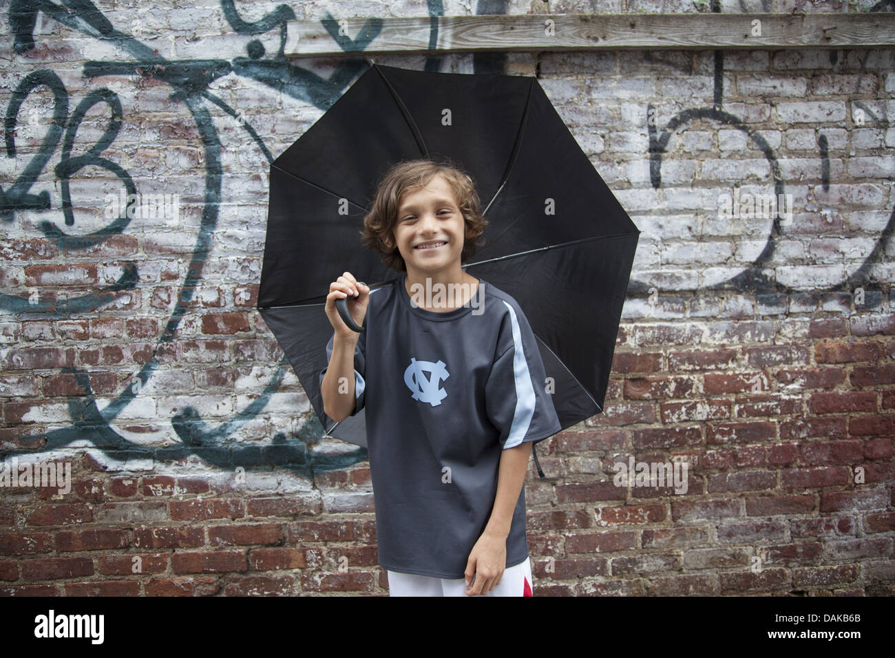 Porträt eines glücklichen 9-jährigen Jungen an einem regnerischen Tag in Brooklyn, New York. Stockfoto