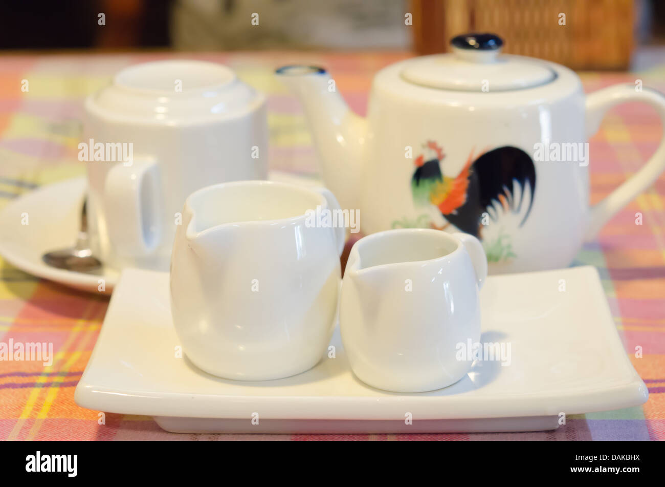 Weiße Milch Krug auf weißen Teller, Teekanne und Tasse auf Teller Stockfoto
