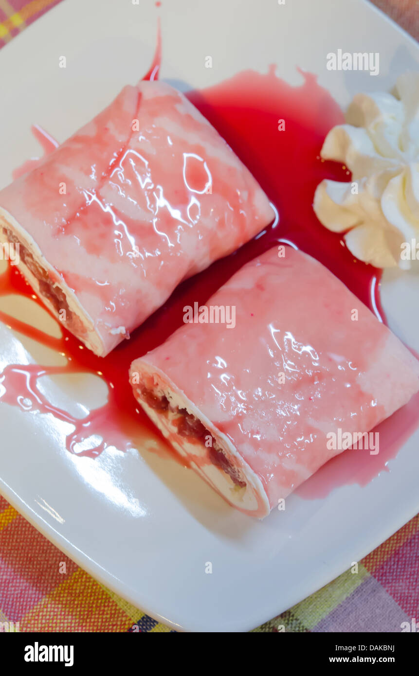 Ansicht von oben Krepp Brötchen gefüllt mit weißen Sahne und Erdbeeren, mit Erdbeer-Sirup Stockfoto