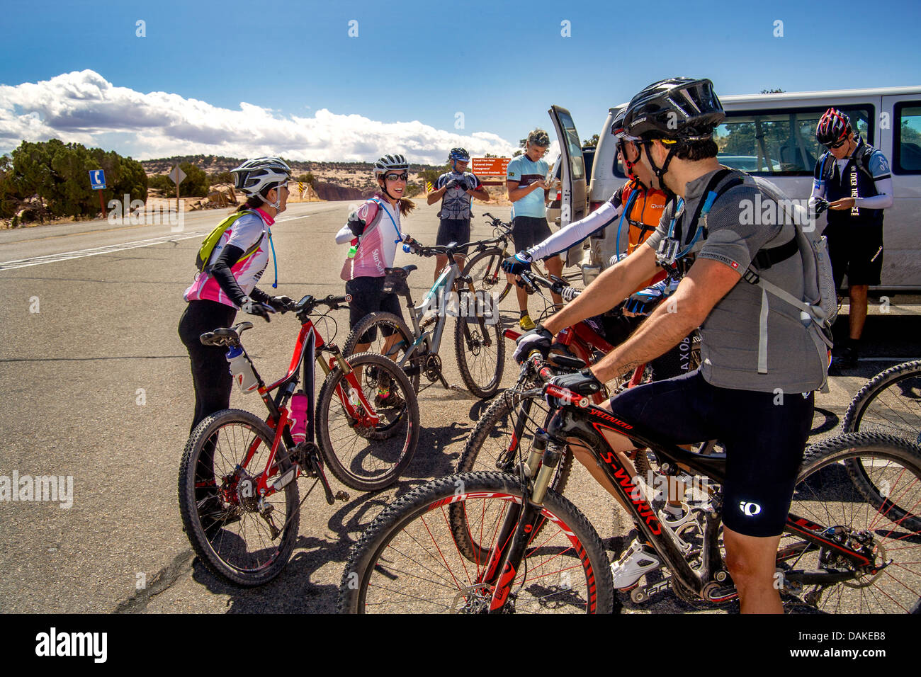 Mit Helmen und spezielle Kleidung, grüßt ein italienischen Gebirgsverein Fahrrad zwei weibliche Mitglieder in Utah am Straßenrand. Stockfoto