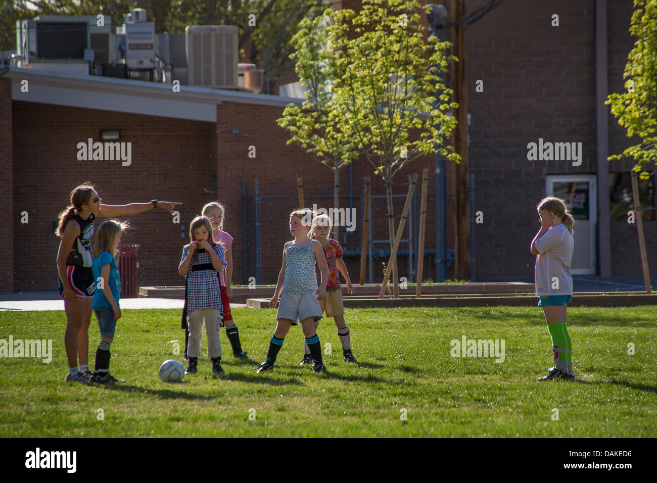 Ein weibliche Fußball-Trainer weist elementare SchülerInnen während nachmittags Praxis in Leeds, Utah. Stockfoto