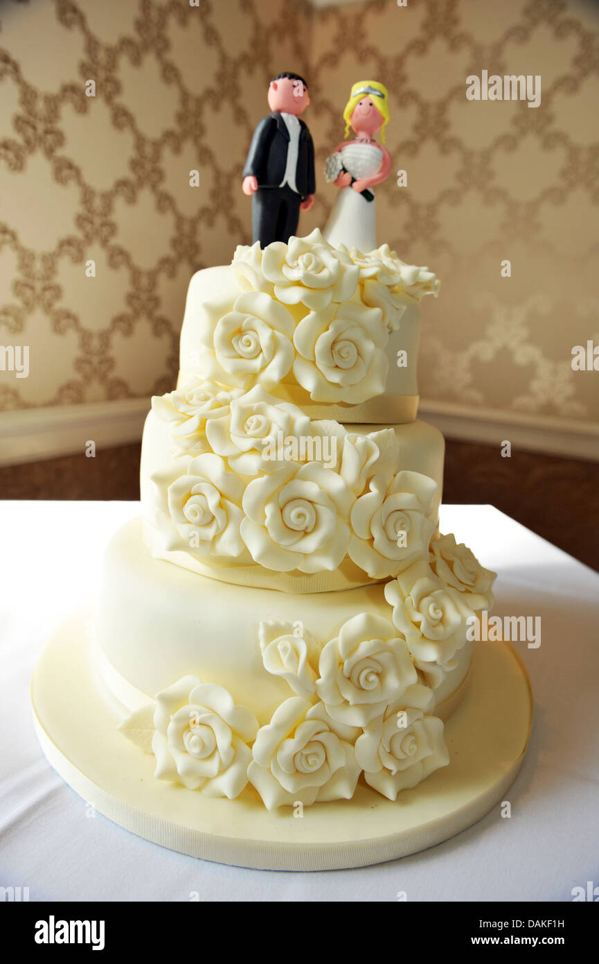 Hochzeit paar Figuren an der Spitze von einem traditionellen weißen Eis Kuchen. Stockfoto