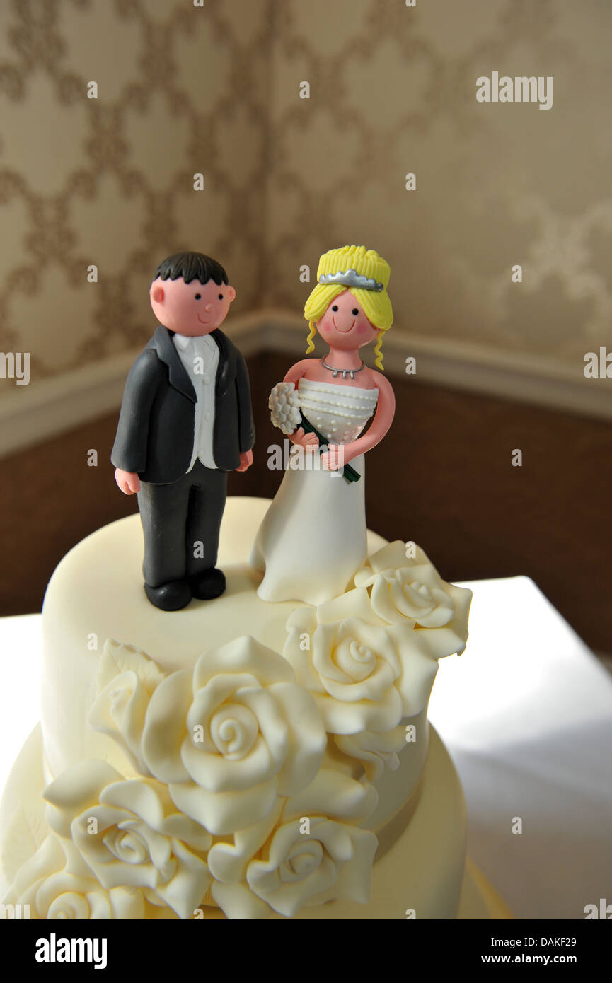 Hochzeit paar Figuren an der Spitze von einem traditionellen weißen Eis Kuchen. Stockfoto