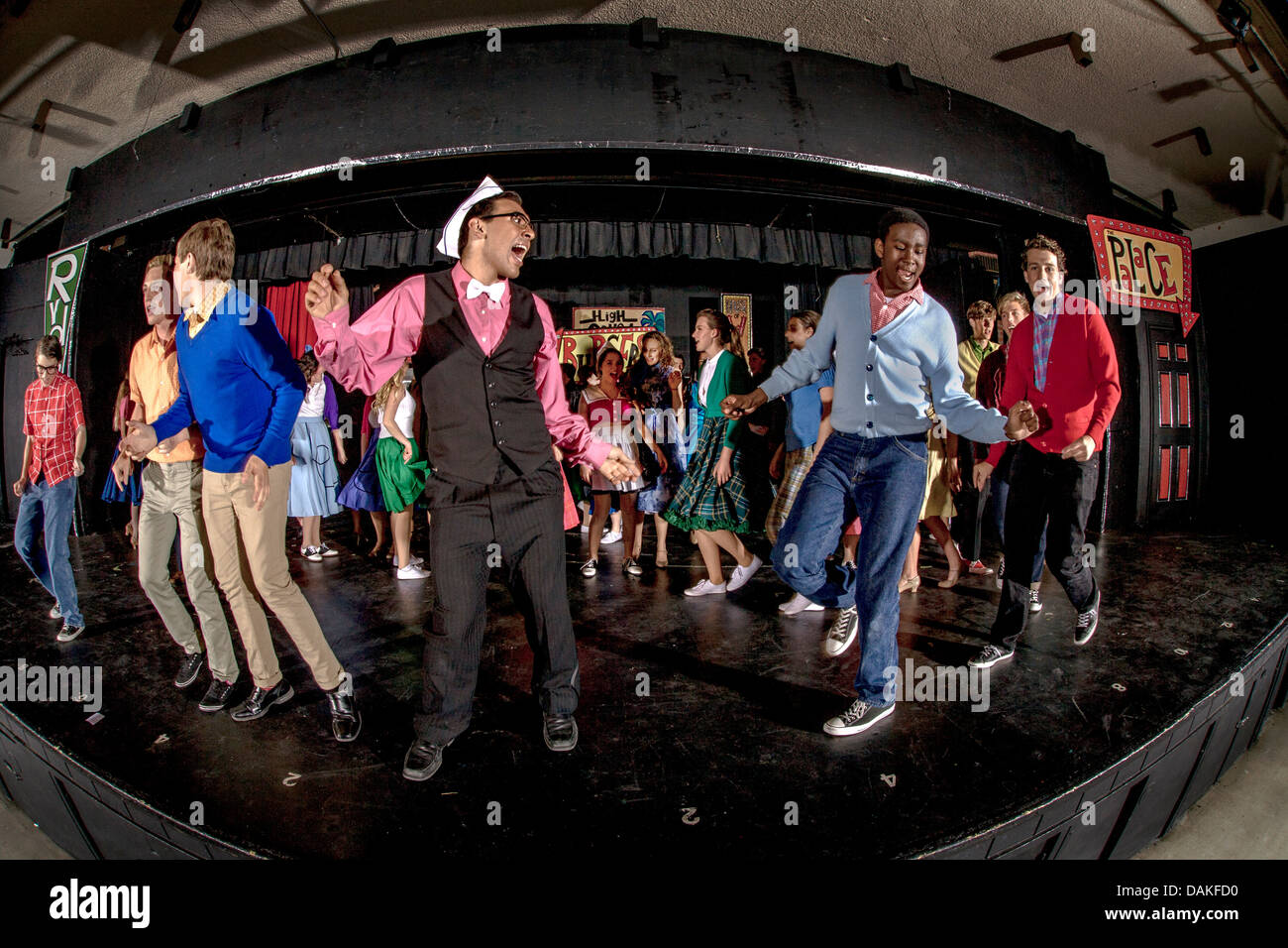 In der 1950er Jahren Kleidung führt die Besetzung einer California Student-Produktion des Musicals "Grease" Ensemble-Reihe. Stockfoto