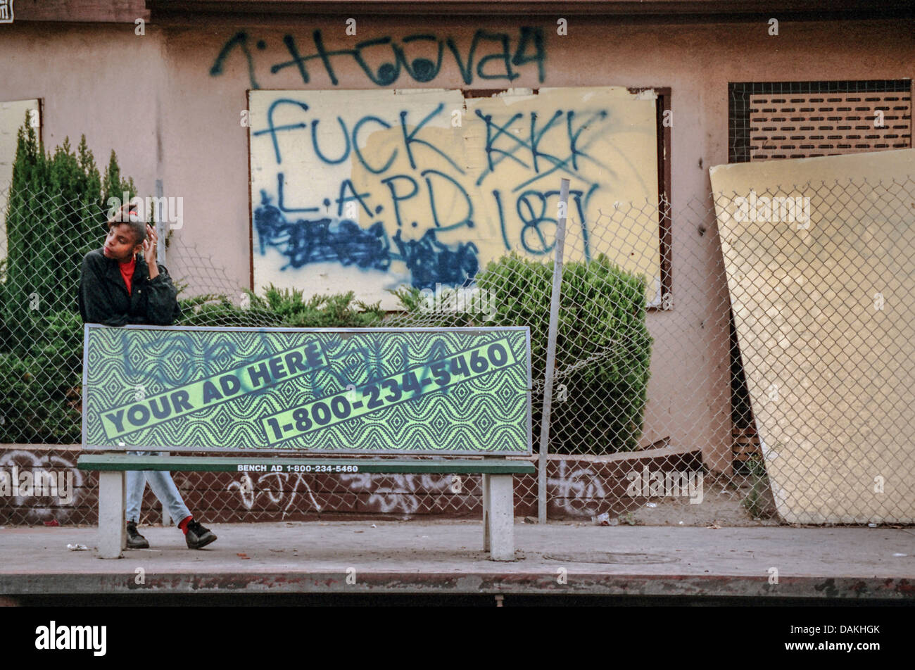 Eine afrikanische amerikanische Frau wartet auf einen Bus in South Central Los Angeles nach 1992 Rodney King Race Riot in Los Angeles. Stockfoto