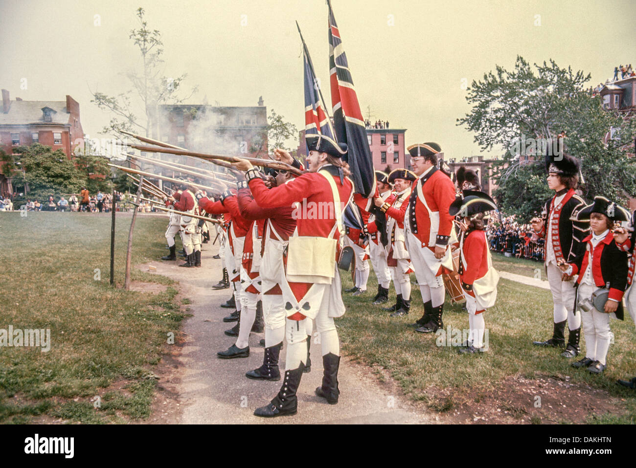 Britische Soldaten entladen Musketen Feuer an 'Patrioten' Verteidigung der Befestigungsanlagen in eine Nachstellung der Schlacht von Bunker Hill. Stockfoto