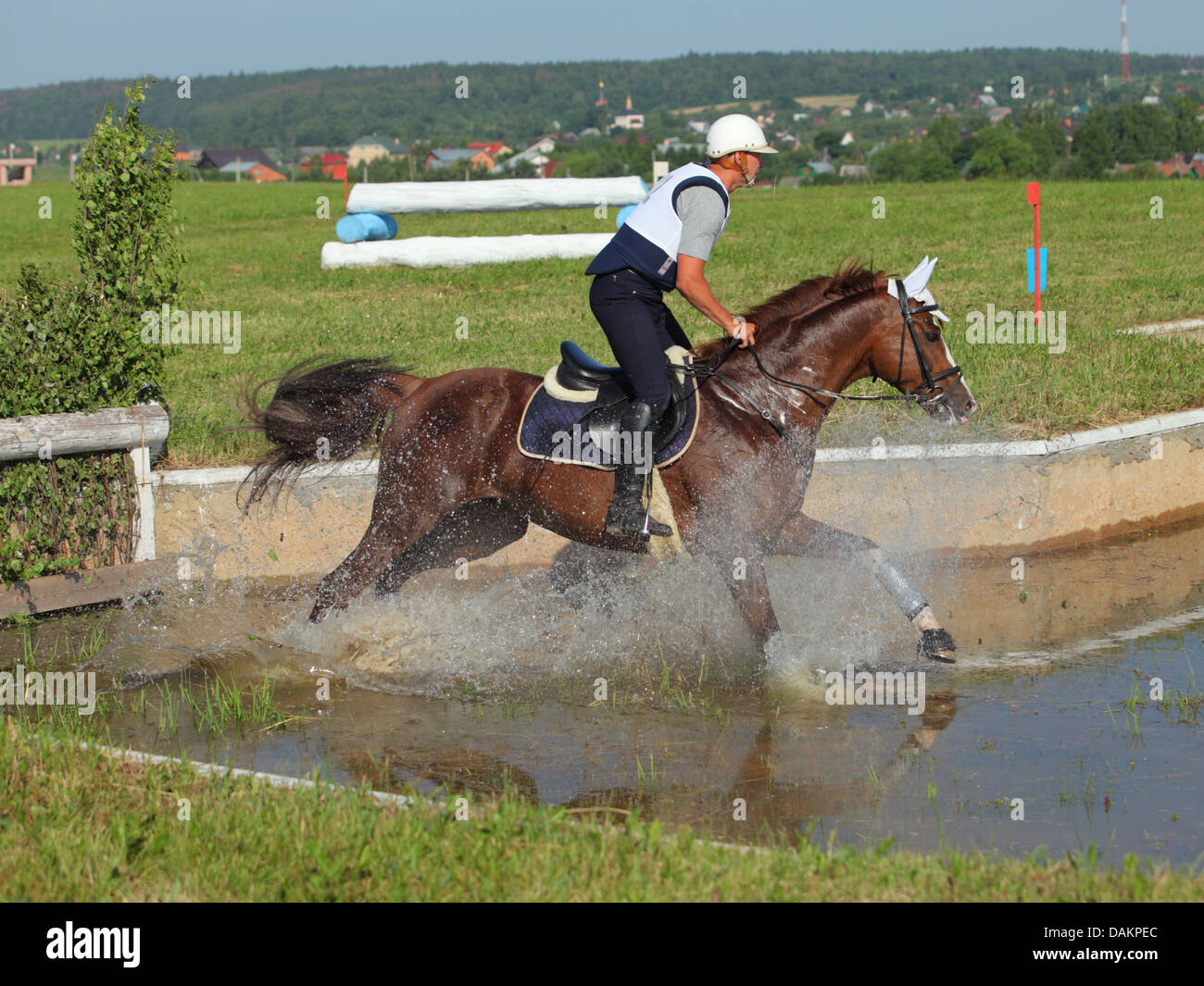 Reiter und Pferd springen aus dem Wasser bei dreitägigen Veranstaltung Horse trials Stockfoto