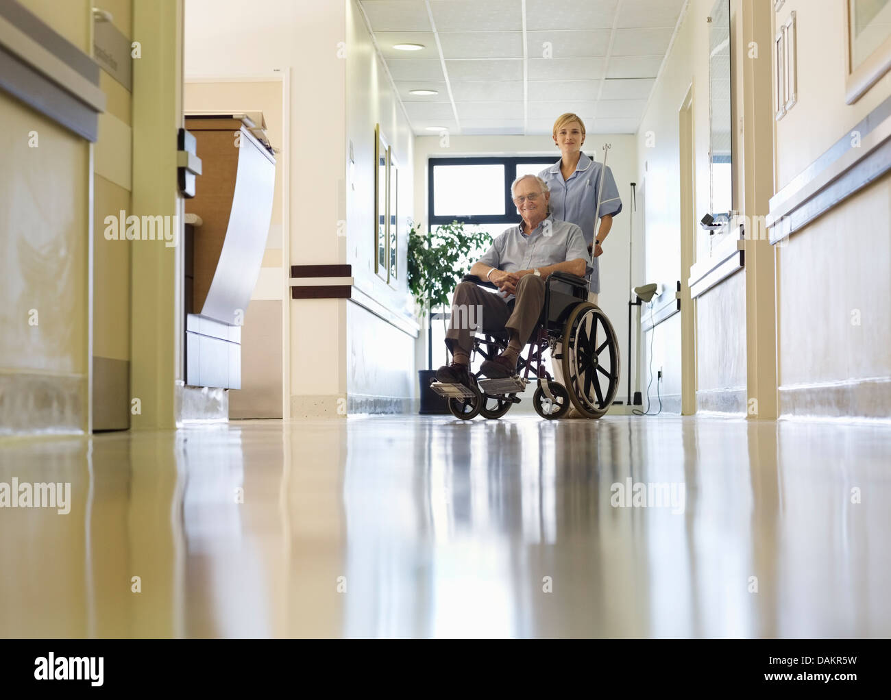 Krankenschwester, wheeling älterer Patienten im Krankenhaus Stockfoto