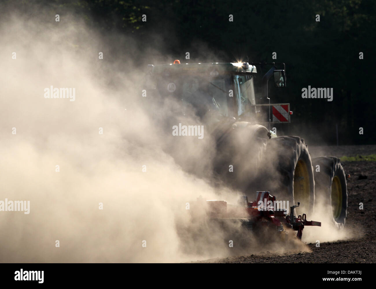 Eine riesige Staubwolke entsteht durch einen Traktor, fahren über ein Feld in grober Luesewitz in der Nähe von Rostock, Deutschland, 4. Mai 2011. Die nächsten Tage bleiben trocken. Foto: BERND WUESTNECK Stockfoto
