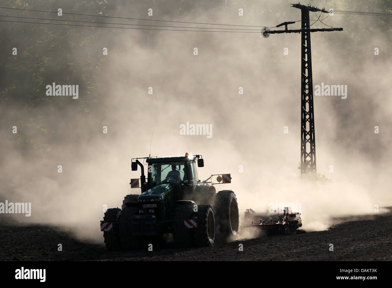 Eine riesige Staubwolke entsteht durch einen Traktor, fahren über ein Feld in grober Luesewitz in der Nähe von Rostock, Deutschland, 4. Mai 2011. Die nächsten Tage bleiben trocken. Foto: BERND WUESTNECK Stockfoto