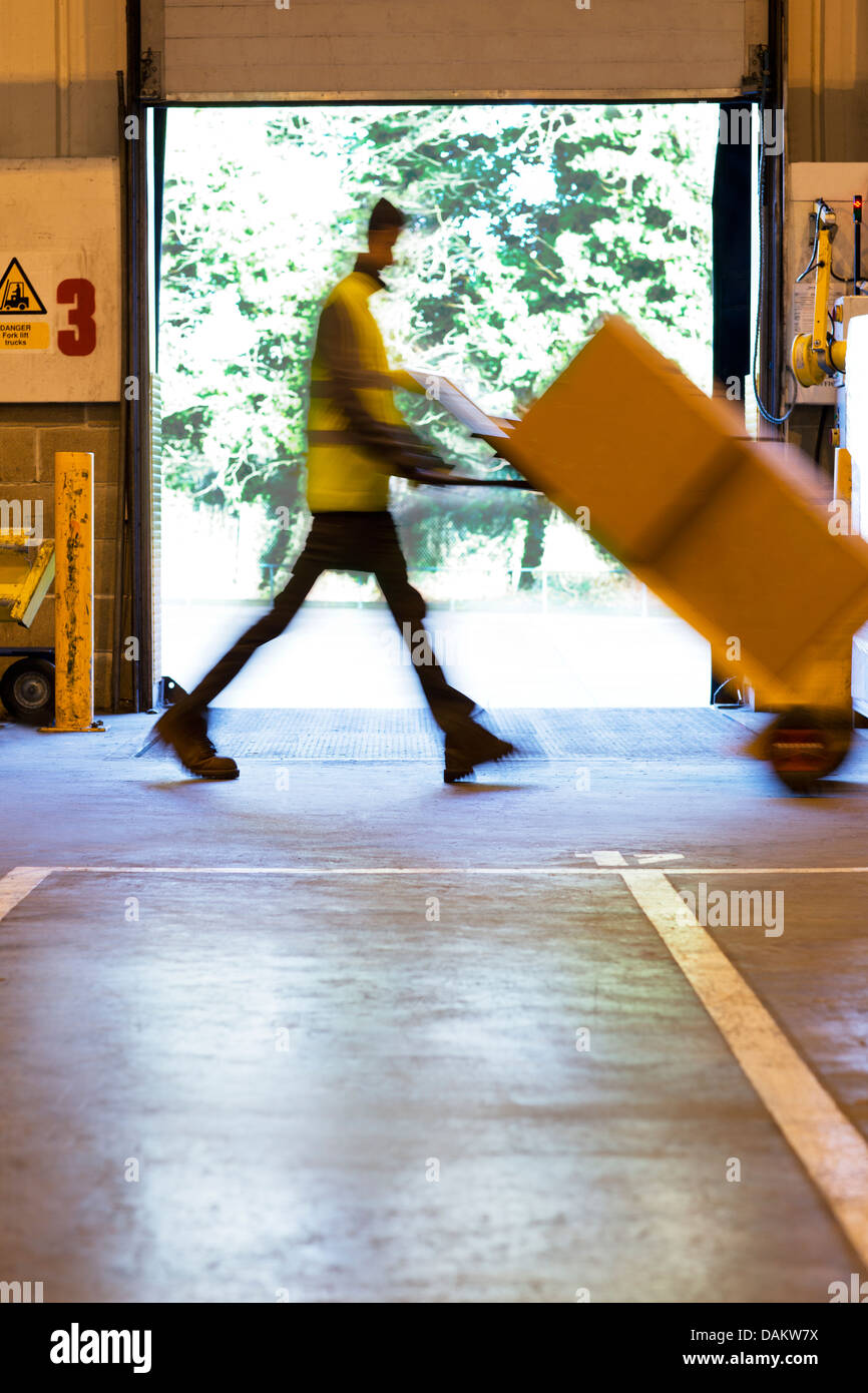 Verschwommene Sicht Arbeitnehmers Kart Kisten im Lager Stockfoto