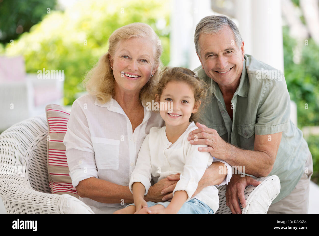 Älteres Ehepaar mit Enkelin auf Veranda Stockfoto