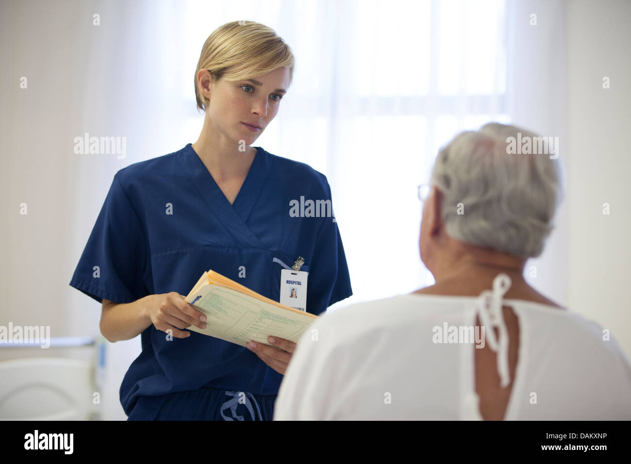 Krankenschwester und ältere Patienten sprechen im Krankenzimmer Stockfoto