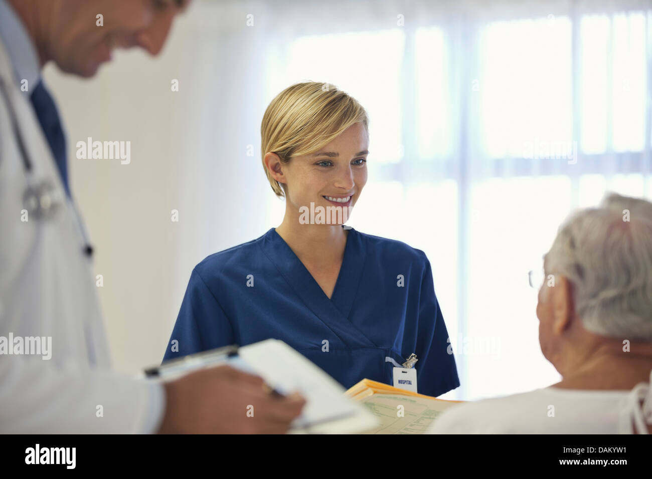 Arzt und Krankenschwester im Gespräch mit älteren Patienten im Krankenzimmer Stockfoto