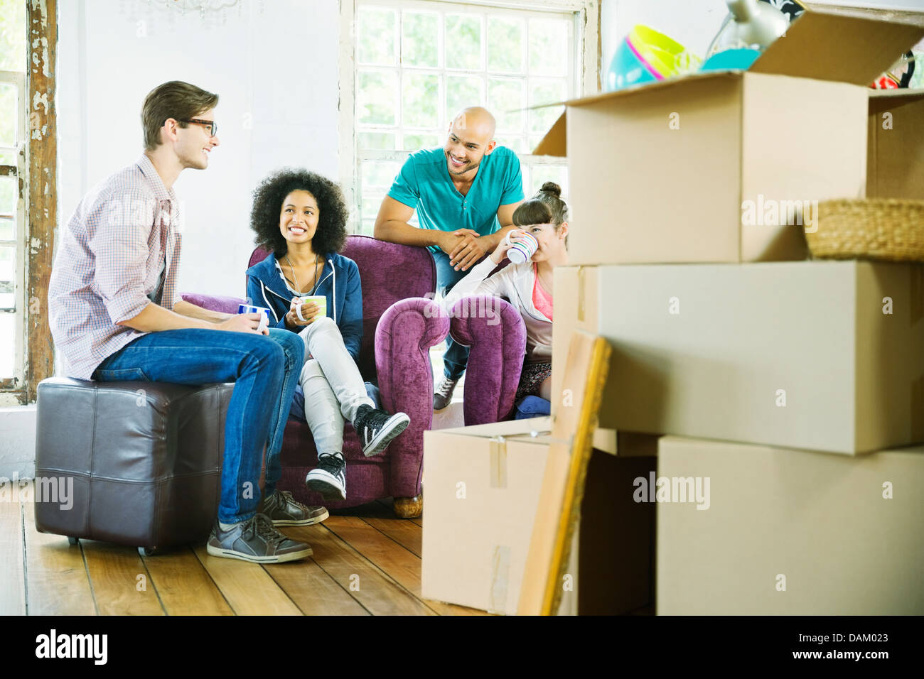 Freunde, die gemeinsam im neuen Zuhause entspannen Stockfoto