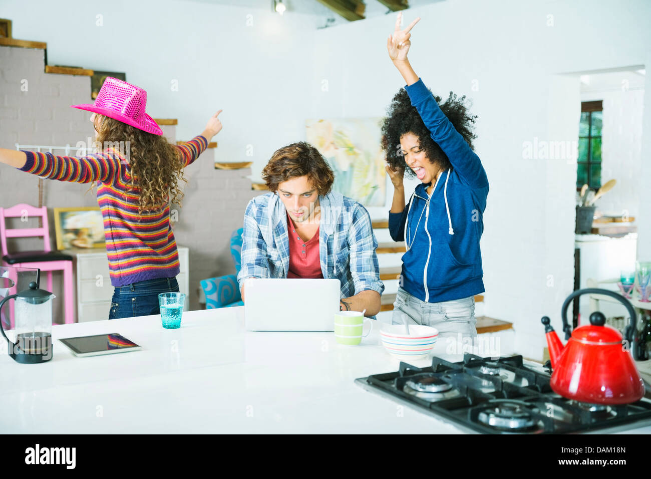 Frauen tanzen um den Menschen in Küche Stockfoto