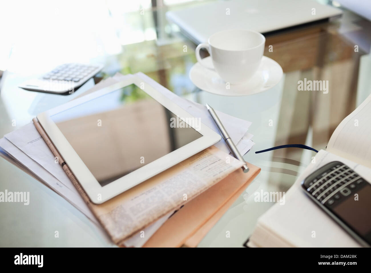 Tablet-Computer, Zeitung, Kaffeetasse und Handy auf Schreibtisch Stockfoto