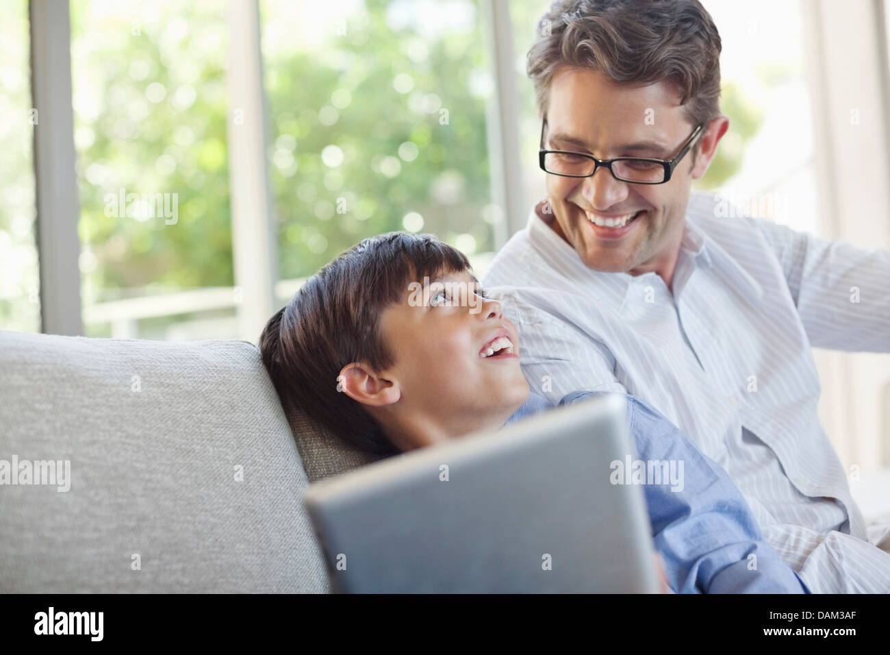 Vater und Sohn mit Tablet-PC auf sofa Stockfoto