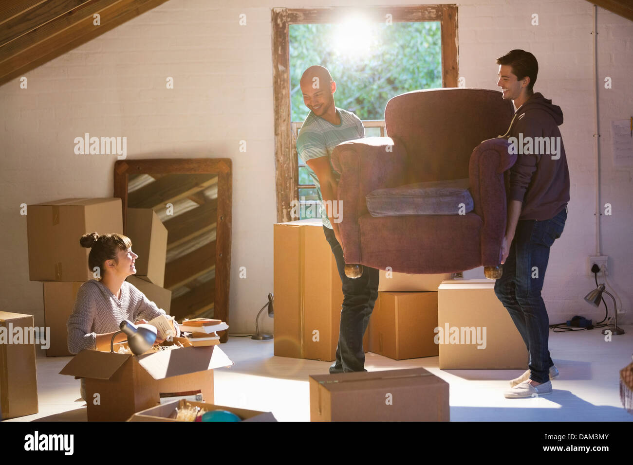 Freunde, die bewegliche Möbel im neuen Zuhause Stockfoto