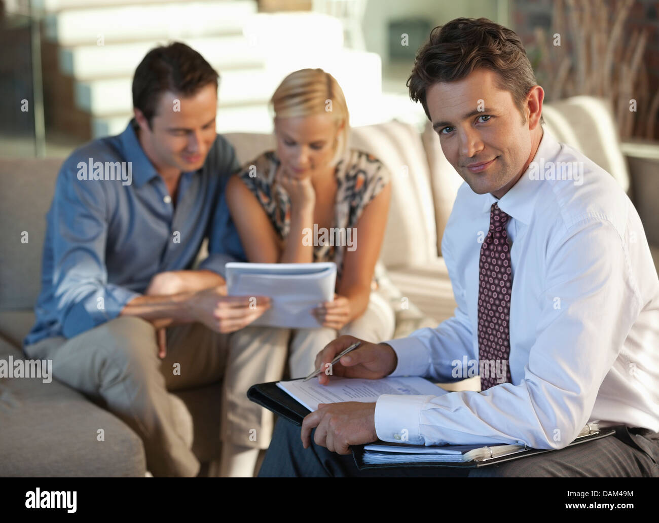 Finanzberater mit paar auf sofa Stockfoto
