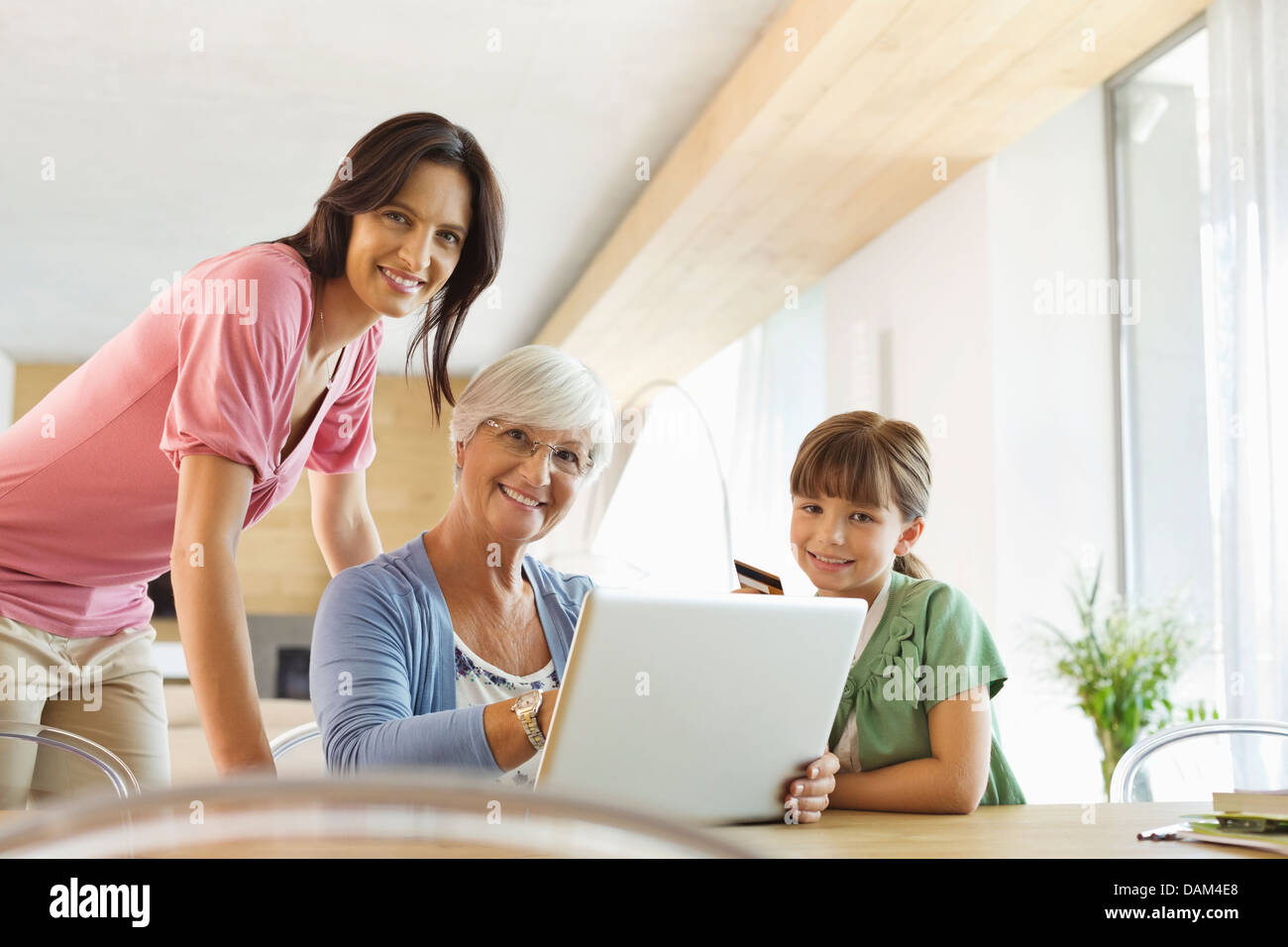 Drei Generationen von Frauen, die mit Laptop zusammen Stockfoto